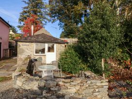 An outdoor area with a cottage and seating at Bwthyn Bach in Pentrefelin