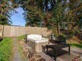 An outdoor area with a hot tub and seating at Bwthyn Bach in Pentrefelin