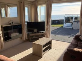 A living room with a sofa and a tv at Trecco Bay holiday park, Porthcawl