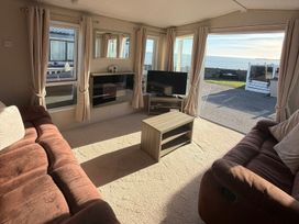 A living room with a television and coffee table at Trecco Bay holiday park, Porthcawl