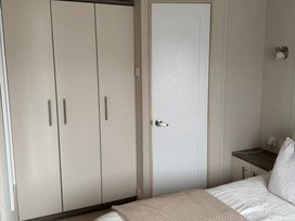 A bedroom with a wardrobe and a bed at Trecco Bay holiday park, Porthcawl