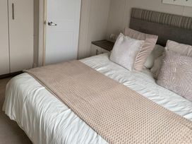 A bedroom with a bed and wardrobe at Trecco Bay holiday park, Porthcawl