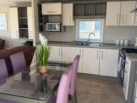 A kitchen with dining table and chairs at Trecco Bay holiday park, Porthcawl