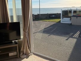 A living room with a television and curtains at Trecco Bay holiday park, Porthcawl