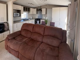 A kitchen with a sofa and appliances at Trecco Bay holiday park, Porthcawl