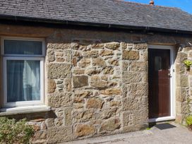 An exterior view showing a stone wall with a window and door at Chyancrowse in Penzance