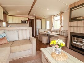 A living room with a sofa and dining table at Roslenn in St Agnes