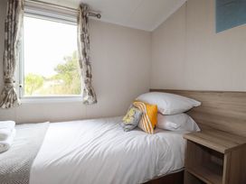 A bedroom with a bed and window at Roslenn St Agnes