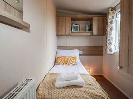 A bedroom with a bed and cabinets at Roslenn in St Agnes