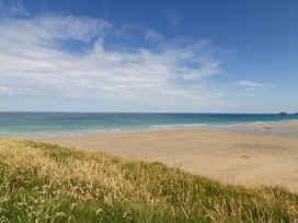 A beach view with grass in the foreground at Roslenn in St Agnes