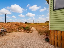 A path leading to a garden with a table and chairs at Roslenn in St Agnes