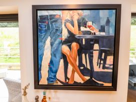 A painting of a woman at a table with a drink at The Barn at Bryn Eithin Colwyn Bay