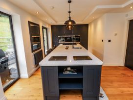 A kitchen with a central island and modern appliances at The Barn at Bryn Eithin, Colwyn Bay