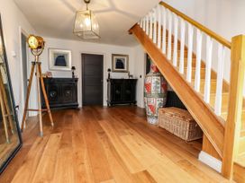 A hallway with a staircase and cabinets at The Barn at Bryn Eithin in Colwyn Bay