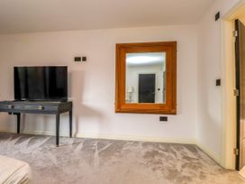 A bedroom with a television and a mirror at The Barn at Bryn Eithin in Colwyn Bay