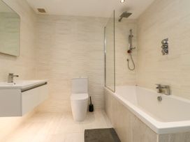 A bathroom with a tub, toilet and sink at The Barn at Bryn Eithin in Colwyn Bay