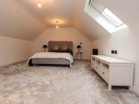 A bedroom with a bed and furnishings at The Barn at Bryn Eithin Colwyn Bay