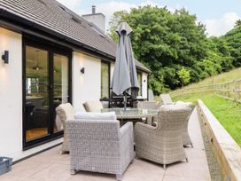 An outdoor seating area with a table and chairs at The Barn at Bryn Eithin Colwyn Bay