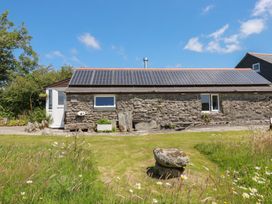 An outdoor view of a stone building with solar panels at Moorland Retreat in Bodmin