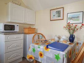 A kitchen with a dining table and a microwave at Moorland Retreat in Bodmin