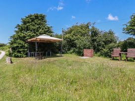 A garden with a table and chairs under a canopy at Moorland Retreat in Bodmin