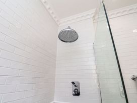 A shower with a showerhead and glass door at Sea View Apartment in Whitby