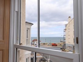 A view from a window looking at the sea and surrounding buildings at Sea View Apartment in Whitby