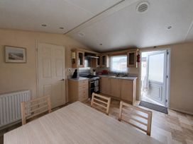 A kitchen with a table and chairs at Marine Holiday Park - 21NC in Rhyl