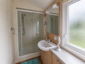 A bathroom with a shower and sink at Marine Holiday Park - 21NC Rhyl