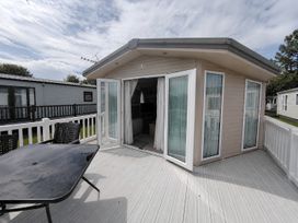 An outdoor area with sliding doors and a table at Marine Holiday Park - 21NC Rhyl