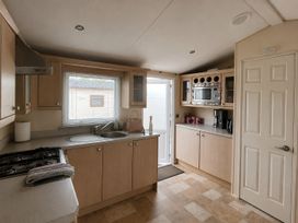 A kitchen with a sink and microwave at Marine Holiday Park - 21NC in Rhyl