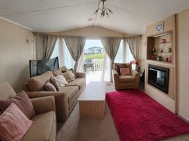 A living room with sofas and a coffee table at Marine Holiday Park - 21NC in Rhyl