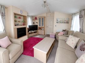 A living room with a sofa and television at Marine Holiday Park - 21NC Rhyl