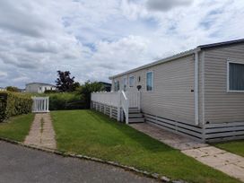An outdoor view of a mobile home with a pathway and grass at Marine Holiday Park - 21NC Rhyl