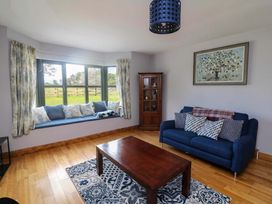 A living room with a window seat and blue sofa at Vernegly in Banonow