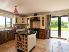 A kitchen with cabinets, an island, and a door to the outside at Vernegly in Banonow