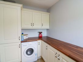 A laundry room with a washing machine and cabinets at Vernegly in Banonow