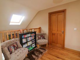 A landing area with a bookshelf and two chairs at Vernegly in Banonow