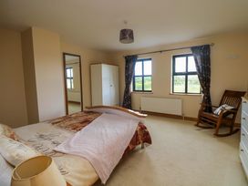 A bedroom with a bed, wardrobe, and rocking chair at Vernegly in Banonow