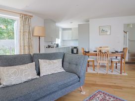 A living room with a sofa and dining area at L'Ancresse Cottage in Lyme Regis