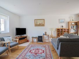 A living room with a sofa and television at L'Ancresse Cottage in Lyme Regis