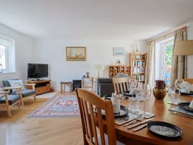 A living room with a dining table and chairs at L'Ancresse Cottage in Lyme Regis