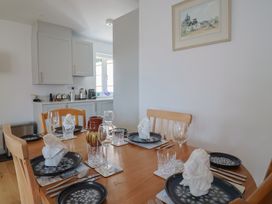 A dining room with a table set for a meal at L'Ancresse Cottage in Lyme Regis