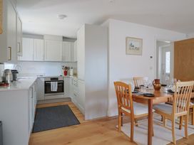 A kitchen with a dining area at L'Ancresse Cottage in Lyme Regis