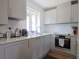 A kitchen with cabinets and appliances at L'Ancresse Cottage in Lyme Regis