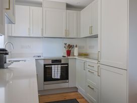 A kitchen with cabinets and an oven at L'Ancresse Cottage in Lyme Regis