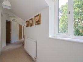 A hallway with a window and pictures on the wall at L'Ancresse Cottage in Lyme Regis