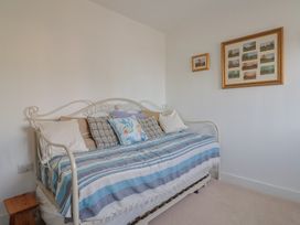 A bedroom with a daybed and framed pictures at L'Ancresse Cottage in Lyme Regis