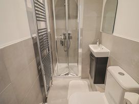 A bathroom with a shower, sink, and toilet at L'Ancresse Cottage in Lyme Regis