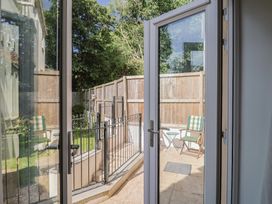A garden view with a patio and chairs at L'Ancresse Cottage in Lyme Regis